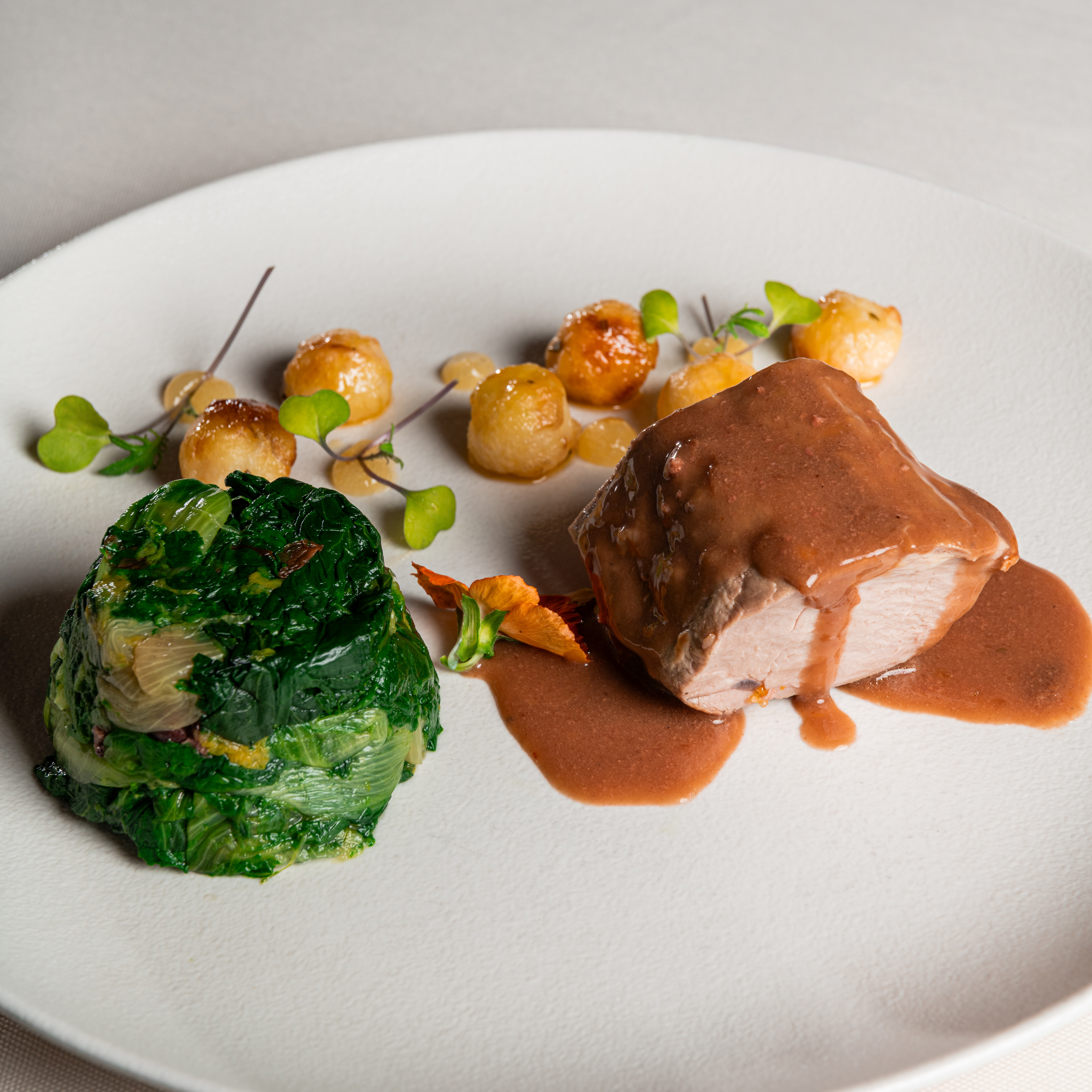 Nobile filetto di maialino con tortino si scarola, patate e gelée di arancia